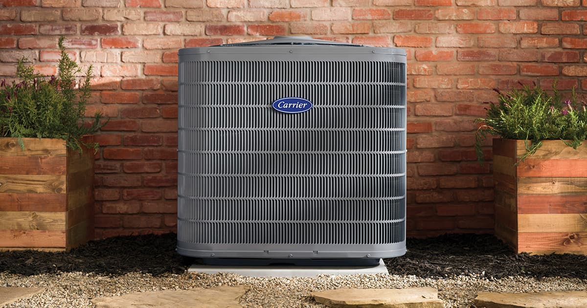 Carrier outdoor air conditioner installed against a brick wall